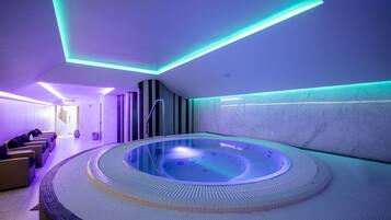 A spa with a circular hot tub, seating area, and modern lighting.