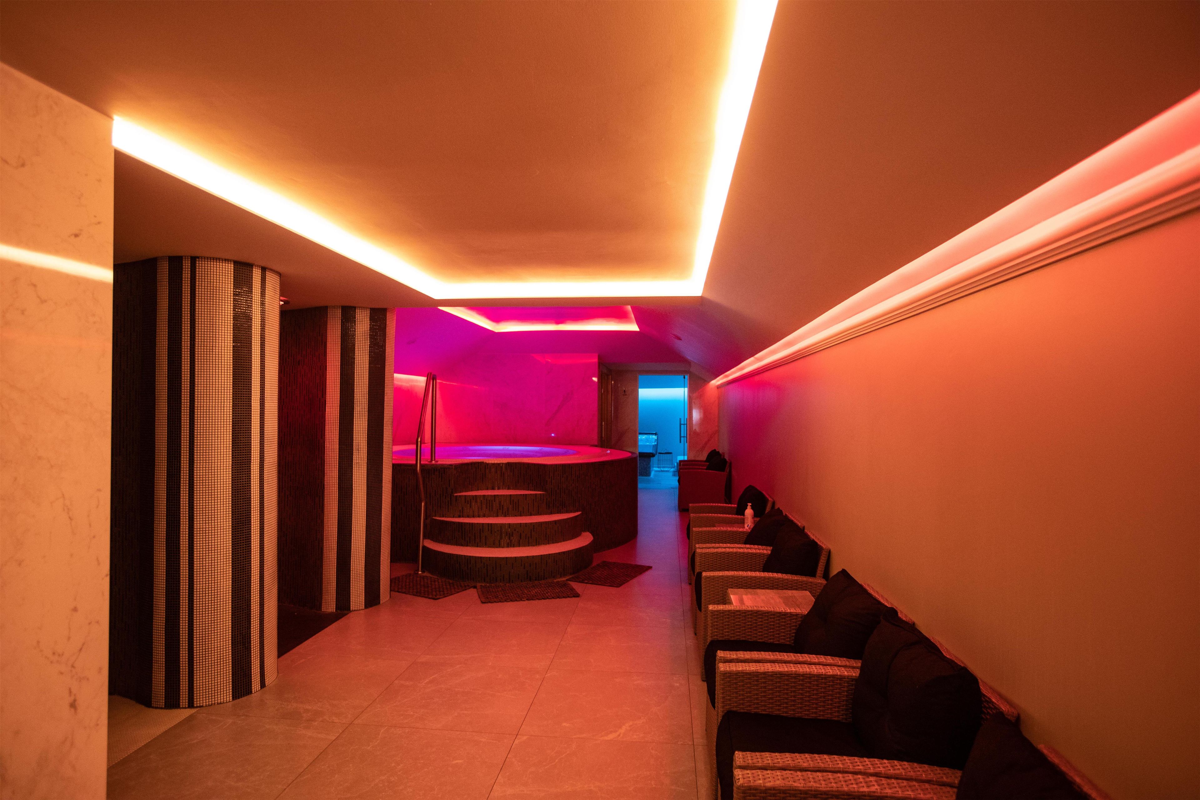 A hallway with a spa area, including a massage table and seating.