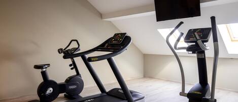 Un gimnasio en casa con dos cintas de correr y una máquina elíptica.