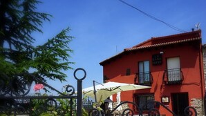 Un edificio rojo con un letrero que dice 'LA CASA NUEVA' y un paraguas blanco.