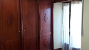 A room with a large wardrobe, a door with a window, and a light-colored carpet. - Apartment 'La Casa Nueva' with Balcony, Wi-Fi and Air Conditioning (Abejar)