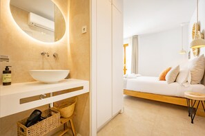 A modern bathroom with a large mirror, white sink, and a wooden bench. - Room 'Altea  03' with Shared Pool, Wi-Fi and Air Conditioning (Altea)