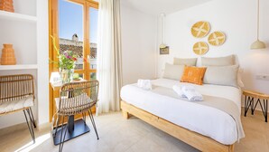 A bedroom with a wooden bed, a window with curtains, a chair, and a table with a vase of flowers. - Room 'Altea  03' with Shared Pool, Wi-Fi and Air Conditioning (Altea)