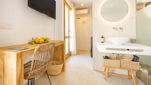 A modern bathroom with a large mirror, white sink, and wicker baskets.
