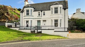 A two-story house with a bay window, a front door, and a small porch. - 3 bedroom accommodation in Portpatrick, near Stranraer (Portpatrick, near Stranraer)