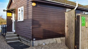 A wooden building with a door, steps, and a sign. - 2 bedroom accommodation in Brundall (Brundall)