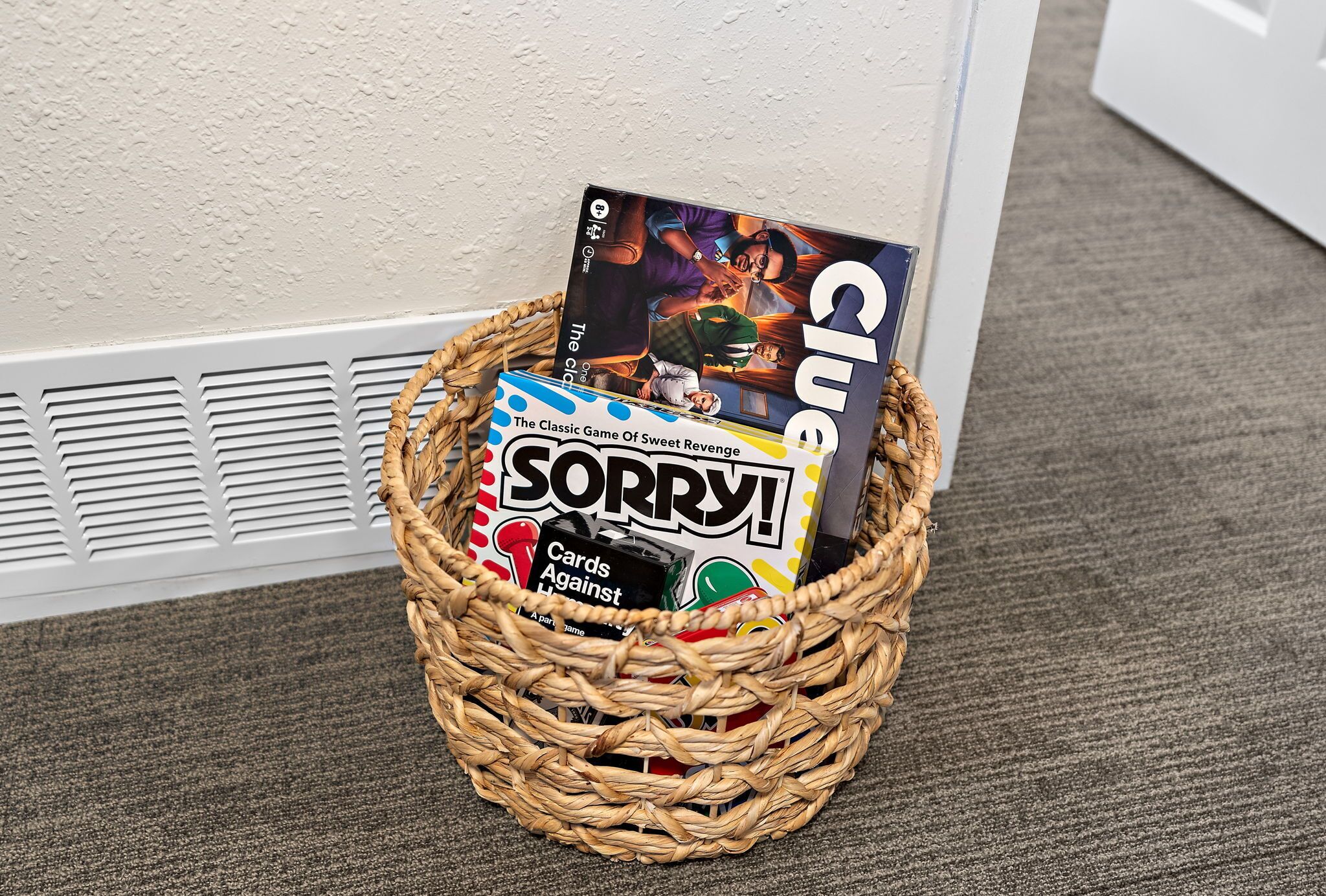 En korg av rotting som innehåller brädspel, bland annat ”Sorry!” och ”Cluedo”.