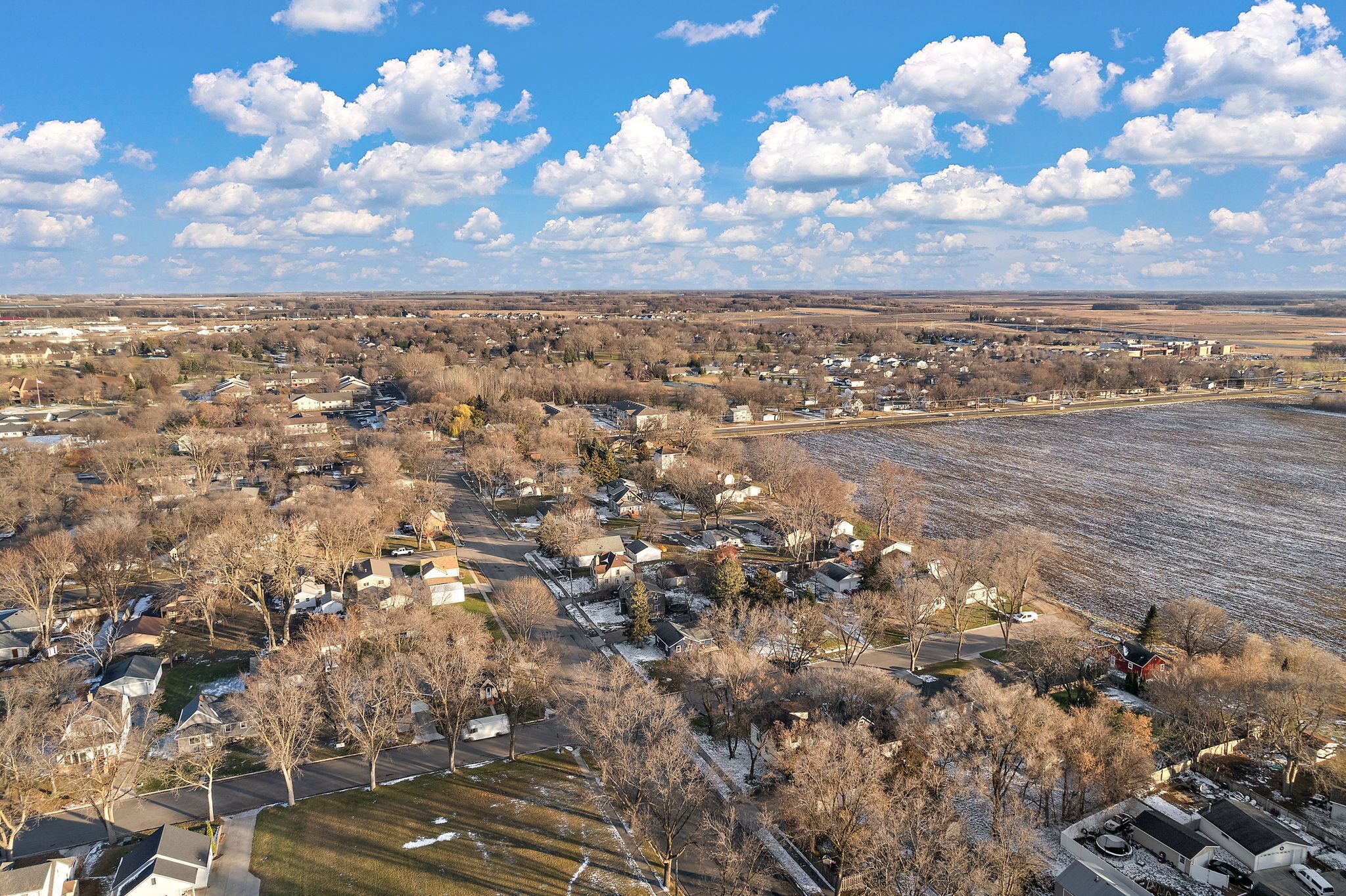 Vista aérea de una zona residencial con casas, caminos y campos.