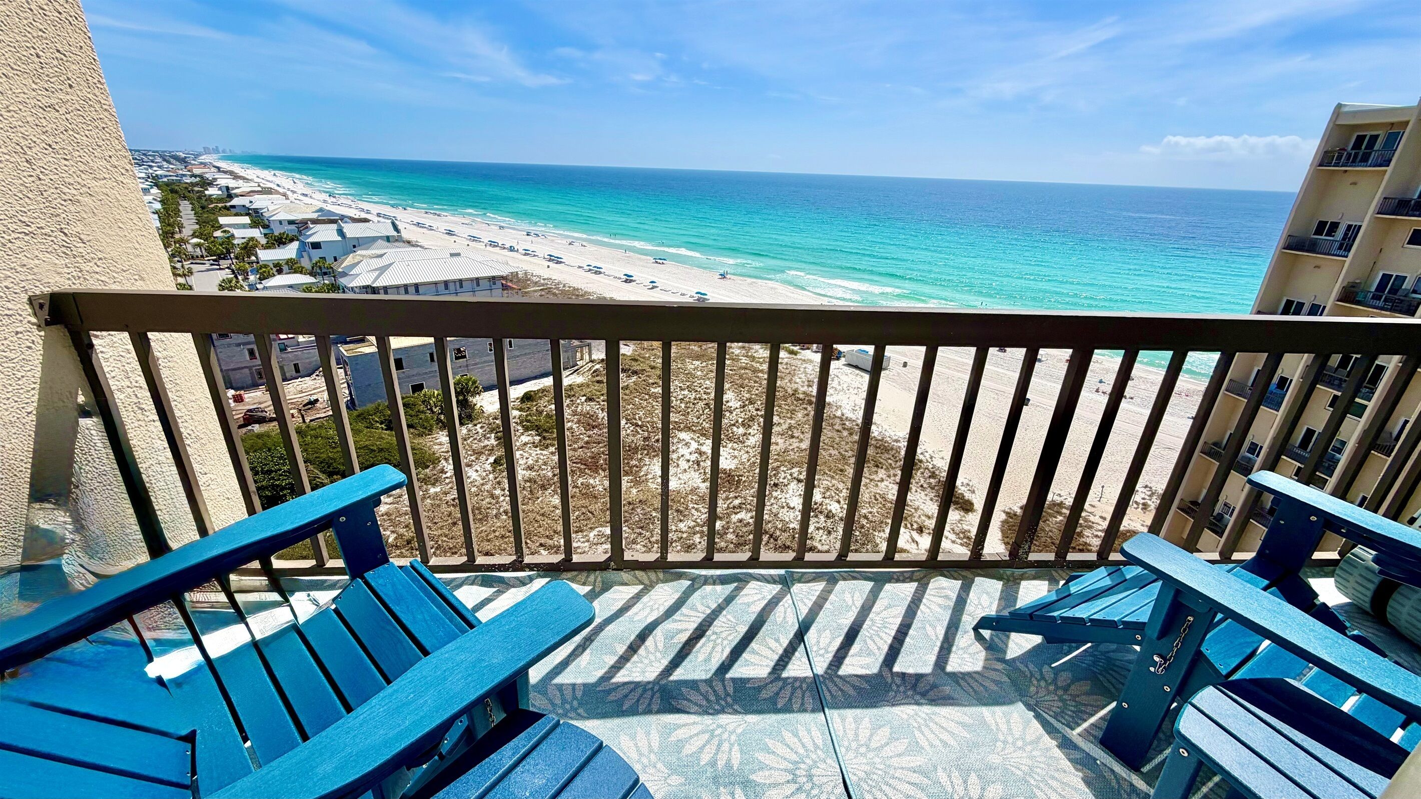 A balcony with a view of a beach and ocean.