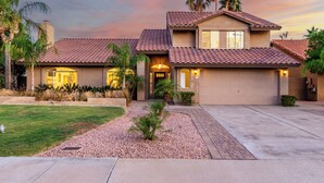 A two-story house with a tiled roof, a garage, and a well-maintained lawn. - Spanish Wells Scottsdale Oasis (Scottsdale)
