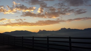 A mountain landscape with a wooden fence in the foreground.