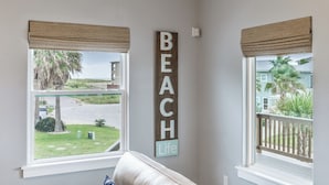 A room with a large window, a beige wall, and a sign that reads "BEACH Life". - 4/4. Pool & Golf Cart.  1st Floor Master Suite.  2 Masters Up, Boat Parking.  
 (Port Aransas)