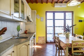 Une cuisine équipée d’armoires, d’un évier et d’un coin repas avec une table et des chaises.