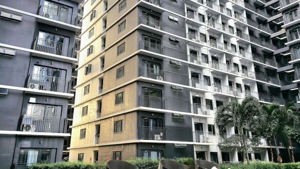 A high-rise residential building with multiple balconies and a swimming pool in the foreground. - Cozy Retreat 1-bedroom unit with pool and balcony in Mall of Asia (MOA) (Pasay)
