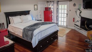 A bedroom with a bed, a red appliance, a television, and a fireplace. - National Harbor Property 1 (Fort Washington)