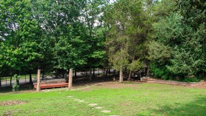 A grassy outdoor area with a wooden bench, stone steps, and a metal fence. - National Harbor Property 1 (Fort Washington)