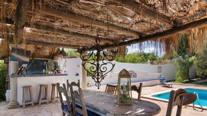 A covered outdoor dining area with a pool and lounge chairs. - Apartment 'Casa De Mondo - Blue Room' with Shared Pool, Wi-Fi and Air Conditioning (Boliqueime)