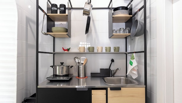 A compact kitchen with a sink, stove, and various utensils.