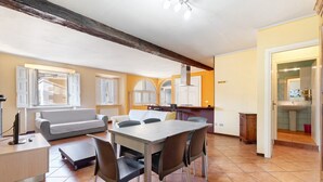 Un grand espace de vie comprenant une table à manger, des chaises, un canapé et un coin cuisine.