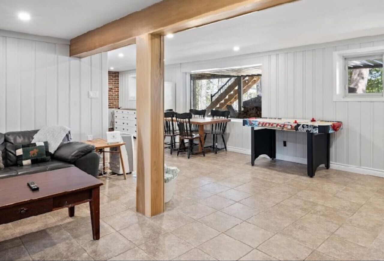 A spacious living area with a sofa, coffee table, and a foosball table.