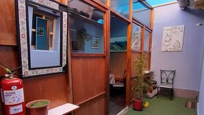 A small, enclosed space with a fire extinguisher, a framed picture, and a potted plant. - We are located in the Historic Center of Cusco, behind the Cathedral, Plaza Mayor. (Cusco)