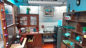 A compact kitchen with a stove, sink, and shelves. - We are located in the Historic Center of Cusco, behind the Cathedral, Plaza Mayor. (Cusco)