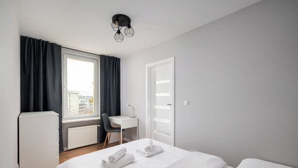 Una habitación de hotel moderna con una cama, un escritorio y una silla.