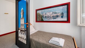 Una habitación de hotel con una cama, un cuadro enmarcado de un paisaje urbano y una puerta con una imagen de la ciudad.