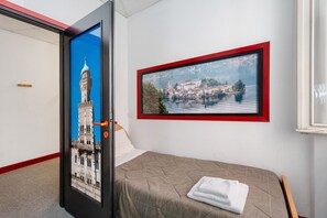 Una habitación de hotel con una cama, un cuadro enmarcado de un paisaje urbano y una puerta con una imagen de la ciudad.