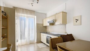 Una cocina funcional con armarios de madera, estufa y comedor con mesa y sillas.