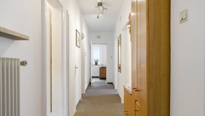 A hallway with white walls, wooden doors, and a ceiling fan. - Room 'Haus Burger Vilpian  4' with Mountain View and Wi-Fi (Vilpiano)
