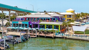 A waterfront restaurant with outdoor seating and a dock with boats.