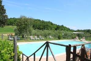 Un área de piscina con sillas de descanso y una valla de madera.
