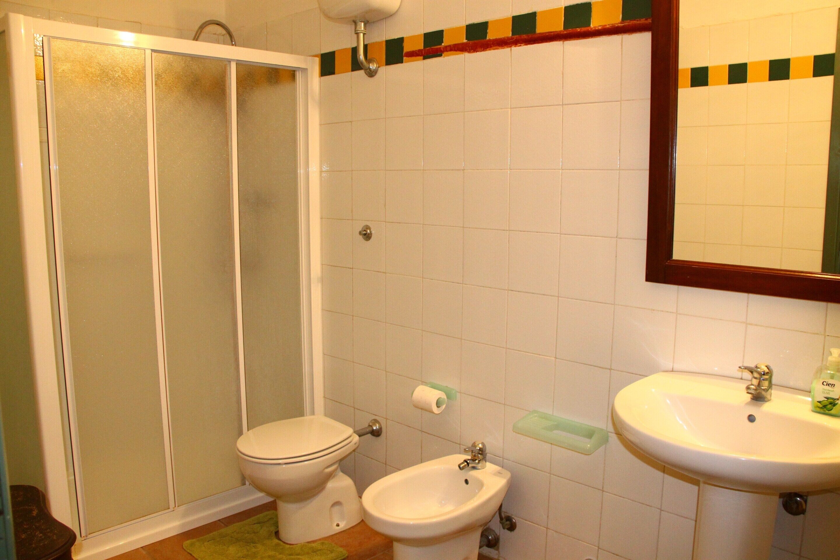 Uma casa de banho com sanita, bidé e lavatório.