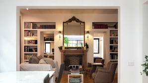 Una sala de estar acogedora con chimenea, estanterías y asientos cómodos.