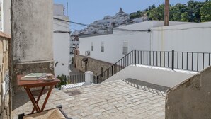 A narrow street with a staircase leading to a white building with a metal railing. - Holiday Home 'De Bárbara' with Balcony and Air Conditioning (Alcalá de los Gazules)