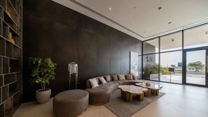 A modern living room with a large sectional sofa, a coffee table, and a potted plant.