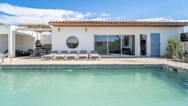 A modern house with a swimming pool, outdoor seating, and a large sliding glass door. - Villa 'Piscine Privée Proche Plages' with Private Pool, Private Terrace and Wi-Fi (Montséret)