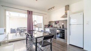 A modern kitchen with a dining area, a refrigerator, and a view through the glass door. - Villa 'Piscine Privée Proche Plages' with Private Pool, Private Terrace and Wi-Fi (Montséret)
