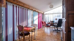 Un coin repas comprenant une table, des chaises et une fenêtre avec des rideaux.