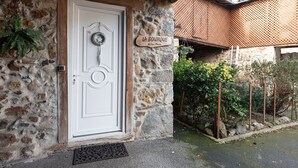 A stone building with a white door, a sign reading 'LA BOUTIQUE,' and a metal wreath on the door.