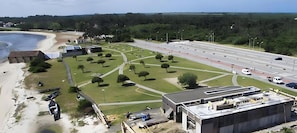 A coastal area with a beach, a road, and a building under construction.