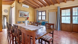 Un comedor con una mesa de madera, sillas y un cuadro en la pared.