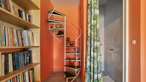 A hallway with bookshelves, a spiral staircase, and a shower area. - Holiday Home 'Palati' with Sea View, Wi-Fi and Air Conditioning (Kefalonia)