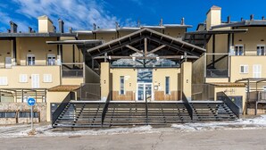 A building with a central entrance, multiple balconies, and a staircase leading to the entrance. - Apartment '42A' with Mountain Views, Private Terrace and Wi-Fi (Sierra Nevada)