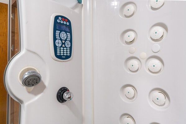 A control panel with multiple buttons and a water jet shower head.