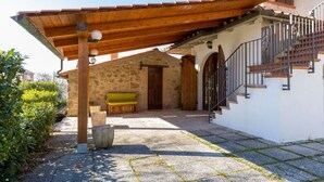 A stone building with a wooden porch, a bench, and a staircase leading to an upper level. - GuestHost - Enchanting and spacious villa on two levels, which in 125 sqm accommodates up to 5 guests with great comfort, being equipped with every type of comfort: two bedrooms and three bathrooms, Jacuzzi tub, large private garden with barbecue and piz (Castel Rigone)