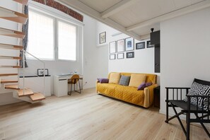 A modern living room with a staircase, a sofa, a desk, and a chair. - GuestHost - MM Jerusalem Subway Loft x4 (Milano)
