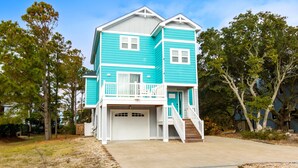 A two-story house with a front porch, a garage, and a small balcony. - Soundside, ELEV, Priv Pool, Hot Tub, Community Amenities- MS853, Resting Beach Place (Corolla)