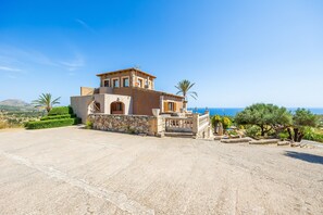 Eine mediterrane Villa mit Steinaußenwand, einem Balkon und Meerblick.